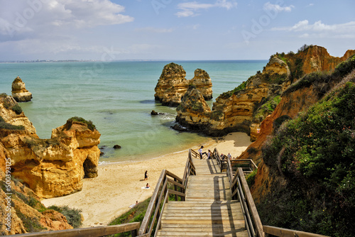 cliff and rocks and wooden footbridge to the beach Praia do Camilo, in Lagos, Algarve, Portugal 