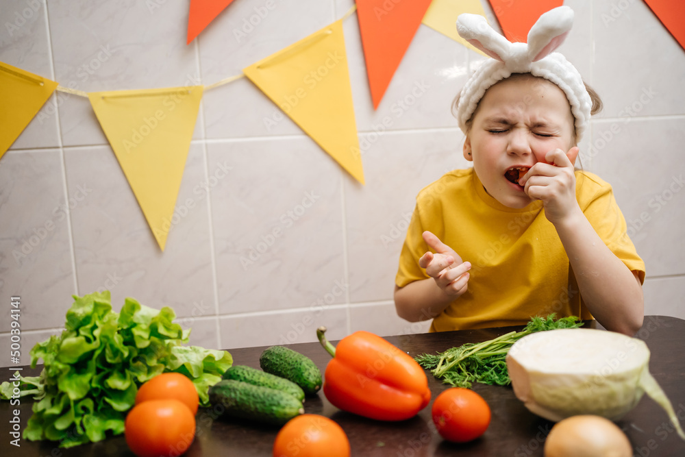baby in rabbit ears eats vegetables Easter copy space baby in rabbit ears eats vegetables Easter copy space