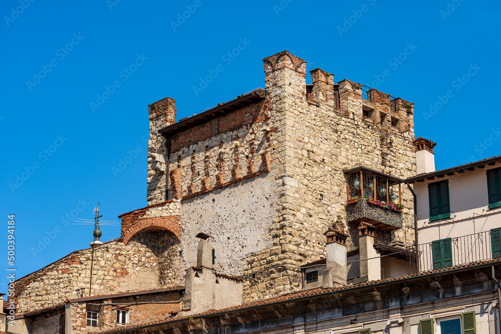 Brescia downtown. Close-up of the Medieval tower called Torre di Porta Bruciata (tower of burnt gate) view from the Piazza della Loggia (Loggia town square). Lombardy, Italy, Europe.