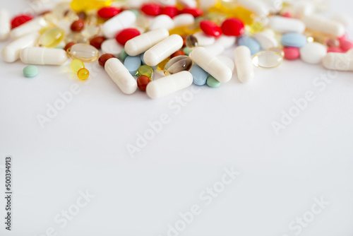 Lekarstwa i witaminy w tabletkach rozsypane na białym tle, suplementacja diety, leczenie przewlekłe, farmacja