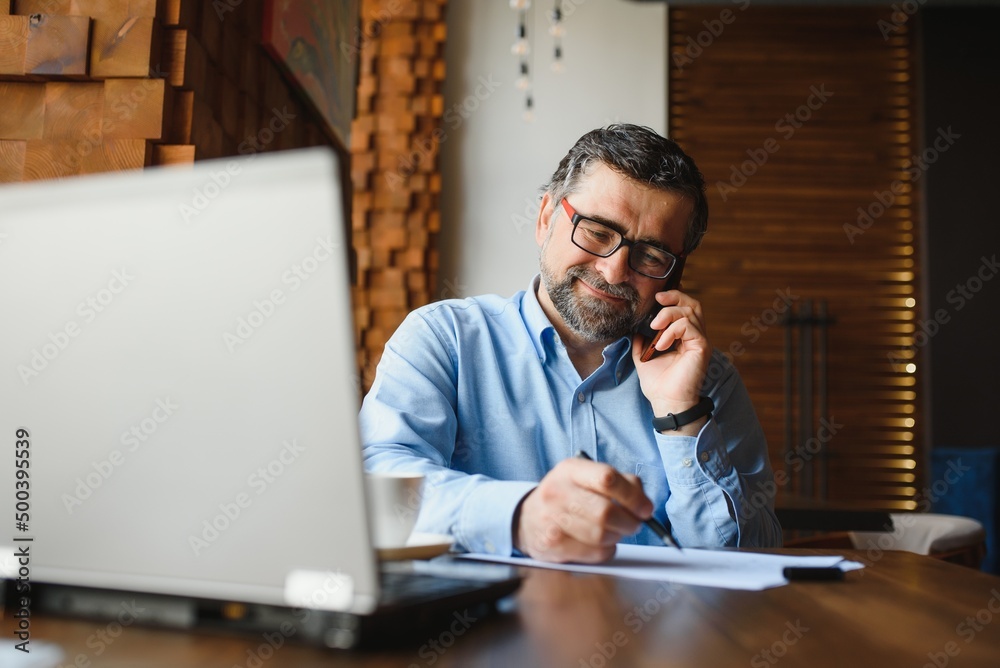 Business, technology and people concept , senior businessman with laptop computer drinking coffee at modern cafe. Business, technology and people concept , senior businessman with laptop computer drinking coffee at modern cafe.
