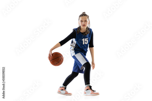 Portrait of teen girl, basketball player in motion, dribbling ball isolated over white studio background © Lustre