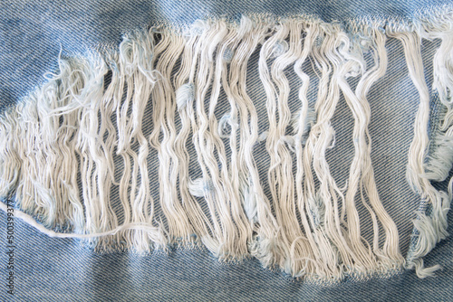 Ripped denim. Coarse blue cotton threads