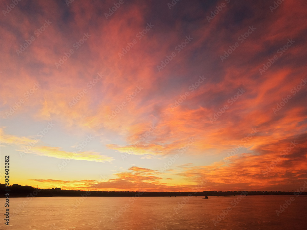 Sunrise over the lake, with red-orange clouds Sunrise over the lake, with red-orange clouds