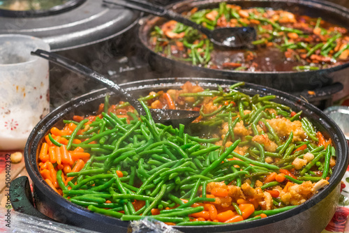 Crispy chicken stir fry with green beans and baby carrots at Brick Lane market in London
