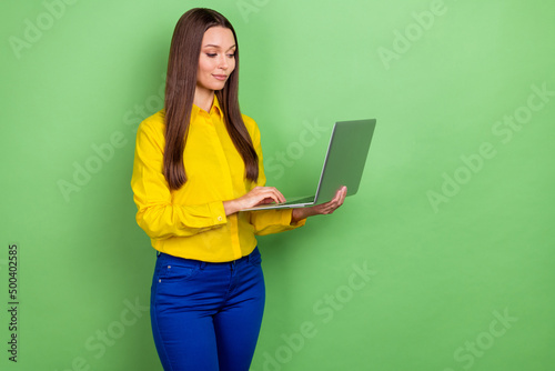 Photo of smart millennial brown hairstyle lady look laptop wear shirt pants isolated on green color background