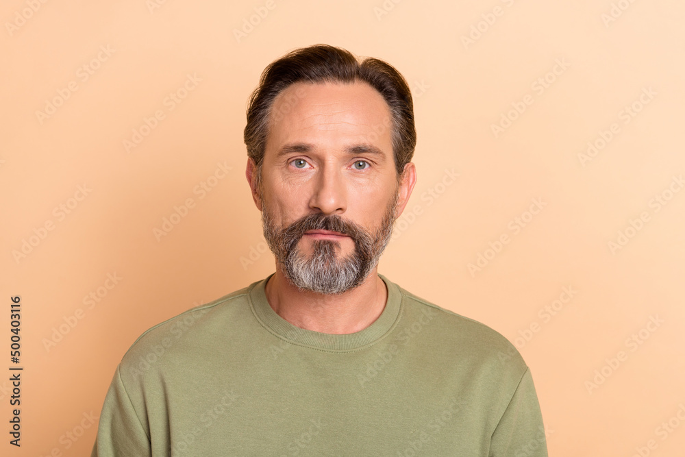 Photo of intelligent calm person look camera nice stubble isolated on pastel beige color background Photo of intelligent calm person look camera nice stubble isolated on pastel beige color background