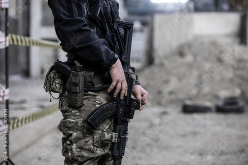 Military soldier in uniform holding a rifle. Man in camouflage with automatic gun.