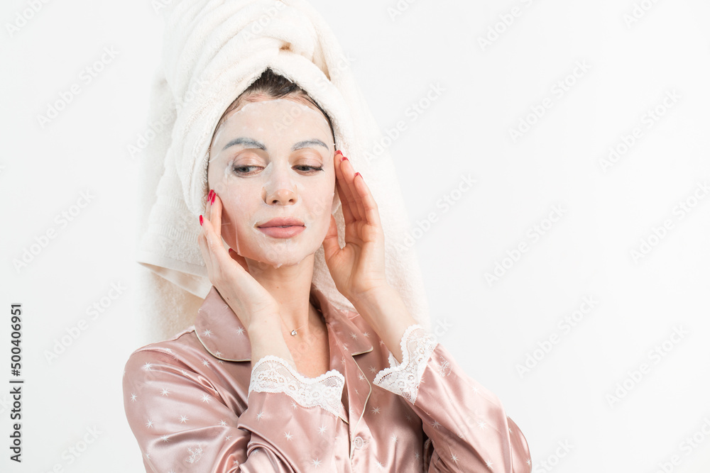 Face care and beauty treatments. Woman with a sheet moisturizing mask on her face isolated on white background Face care and beauty treatments. Woman with a sheet moisturizing mask on her face isolated on white background