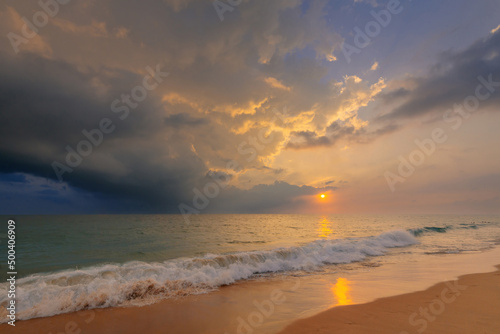 Gorgeous sunset sky with clouds over Indian ocean sandy beach with a foamy wave. Beautiful seascape. © stone36