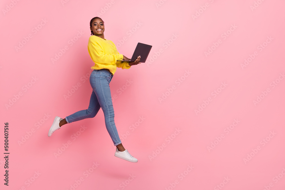 Full length profile side photo of young cheerful girl use laptop jump representative isolated over pink color background Full length profile side photo of young cheerful girl use laptop jump representative isolated over pink color background