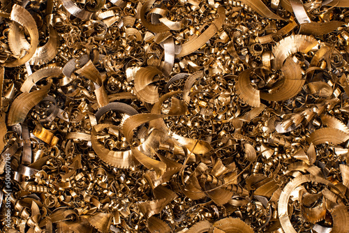 Golden pieces of metal filings photographed in close-up macro in a metal factory