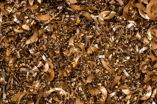 Golden pieces of metal filings photographed in close-up macro in a metal factory