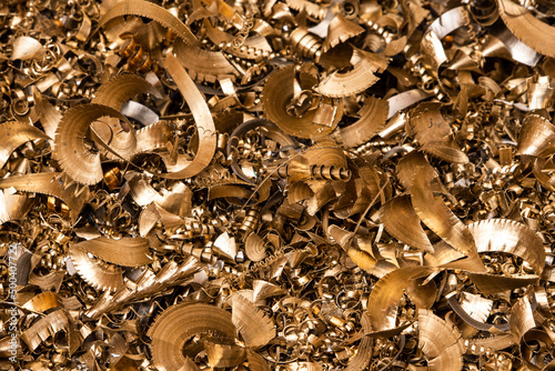 Golden pieces of metal filings photographed in close-up macro in a metal factory