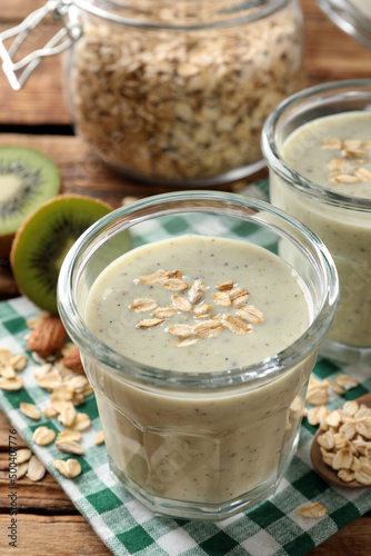 Tasty kiwi smoothie with oatmeal on wooden table