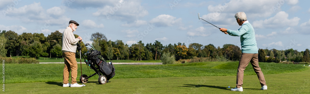 senior asian man playing golf near friend with golf cart, banner. senior asian man playing golf near friend with golf cart, banner.