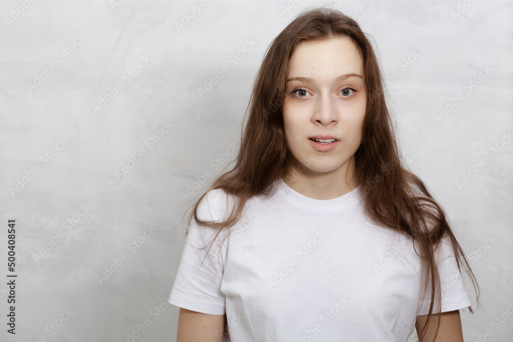 surprised young woman wearing white T-shirt isolated against light background surprised young woman wearing white T-shirt isolated against light background