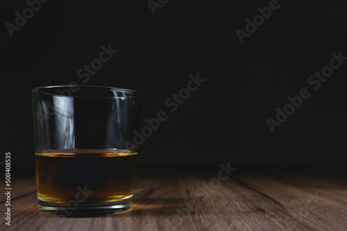 glass with whiskey on a wooden table