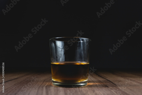 glass with whiskey on a wooden table