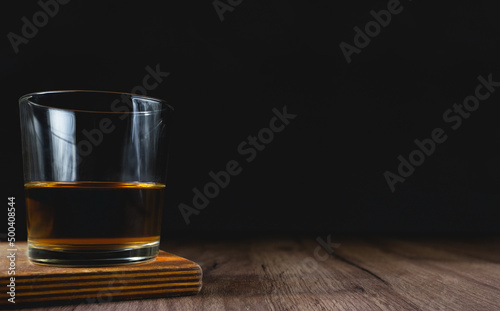 glass with whiskey on a wooden table