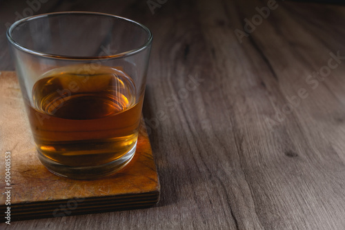 glass with whiskey on a wooden table