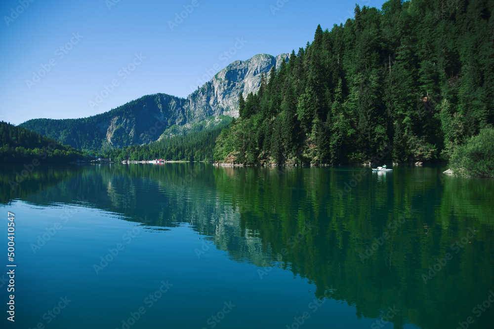 Magnificent view of the summer of the lake in the morning in the rays of the sun. Type of lake in the mountains of the Caucasus. Wildlife during sunrise. Magnificent summer landscape. Ideas for design