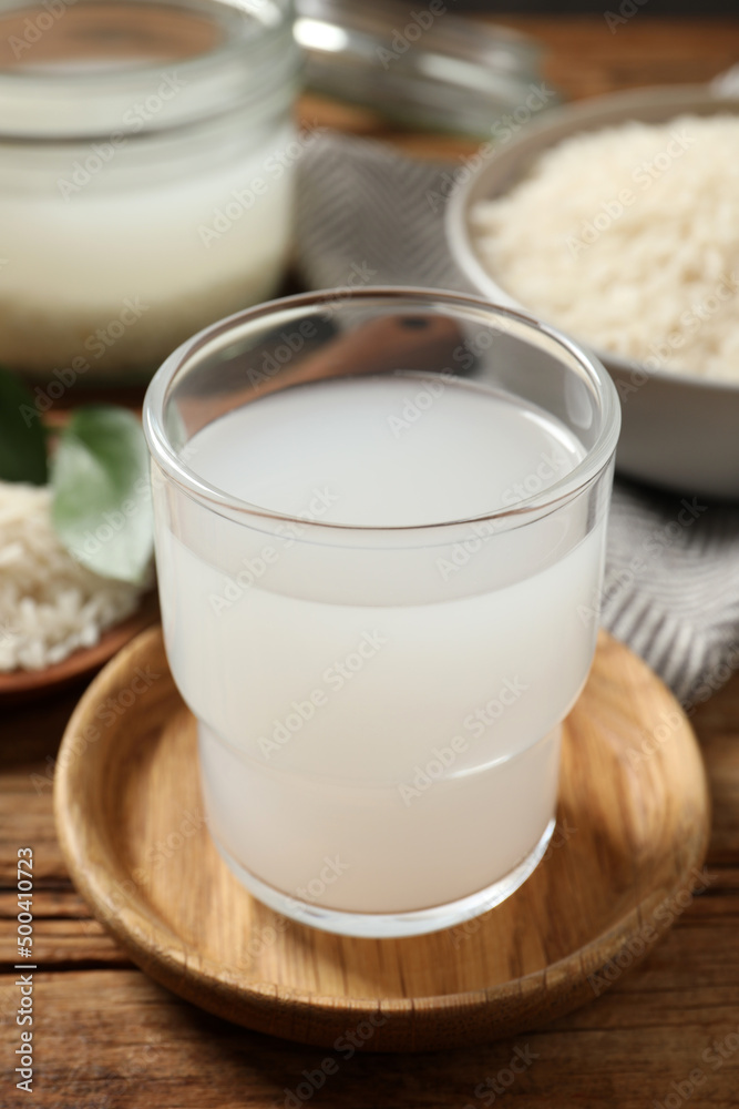 Glass of rice water on wooden table, closeup Glass of rice water on wooden table, closeup