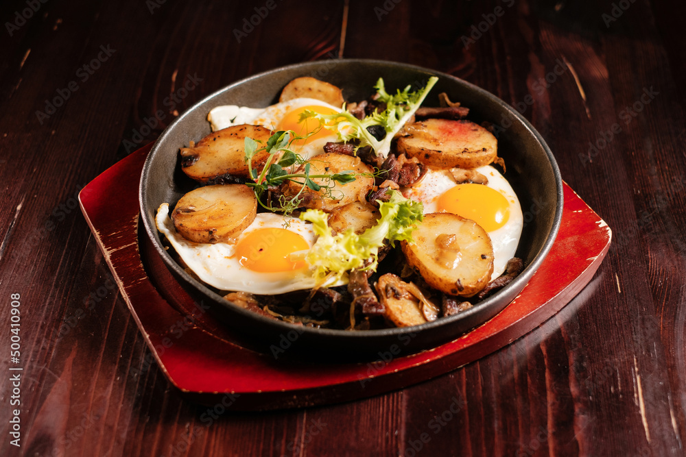 Fried potatoes with egg in a pan. Fine dinning menu. Fried potatoes with egg in a pan. Fine dinning menu.