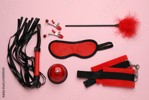 Sex toys and accessories on pink background, flat lay photo