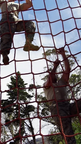 Military troops climbing a net during obstacle course 4k photo