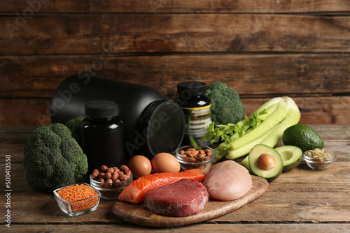 Set of products rich in amino acids and supplements on wooden table photo