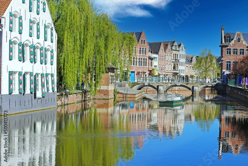 Beautiful belgian landscapes - View over water village moat canal on ancient houses, green weeping willow tree, medieval stone arch bridge, blue clear sky - Lier, Belgium