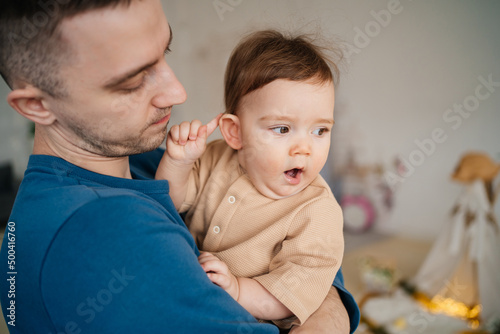 child yawns in the father's arms