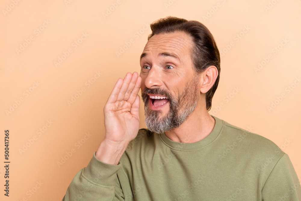 Portrait of attractive cheerful amazed man saying good news advert ad isolated over beige pastel color background Portrait of attractive cheerful amazed man saying good news advert ad isolated over beige pastel color background