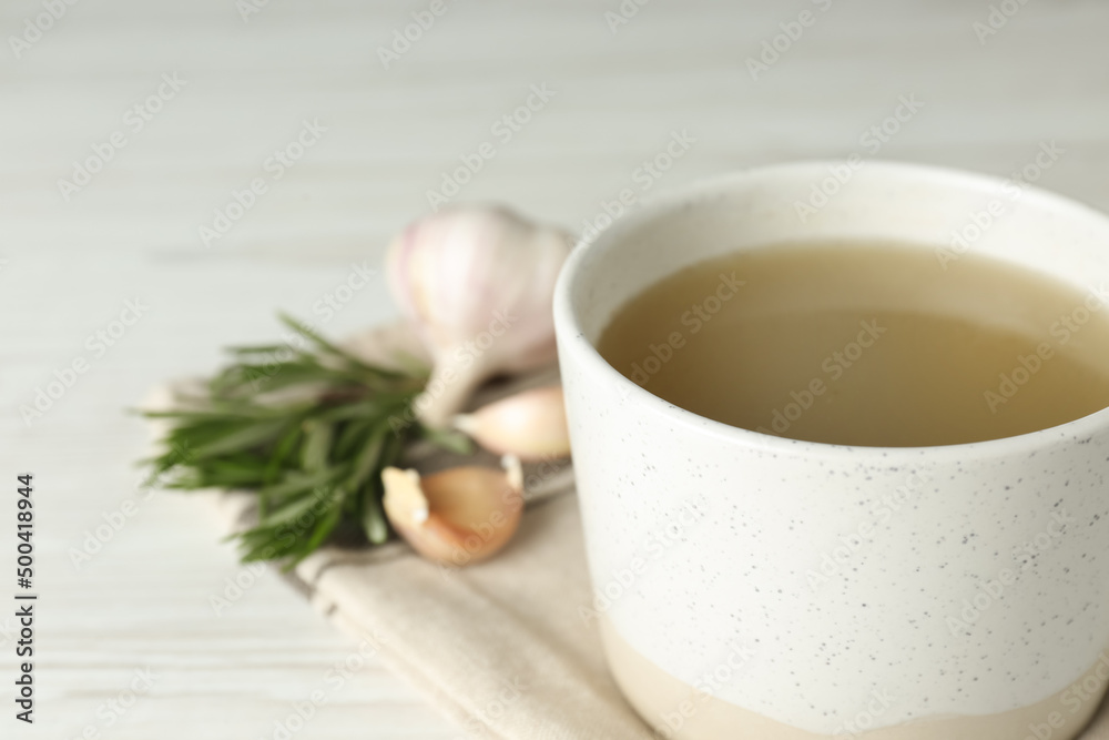 Mug with delicious bone broth on white wooden table, closeup. Space for text Mug with delicious bone broth on white wooden table, closeup. Space for text