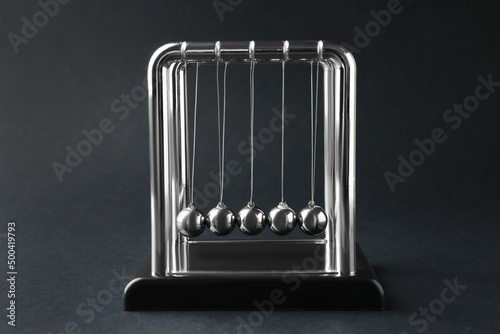 Newton's cradle on dark background. Physics law of energy conservation