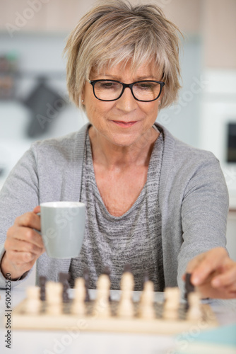 a woman is playing chess alone