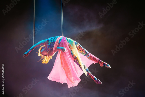 An aerial gymnast shows a performance in the circus arena. photo