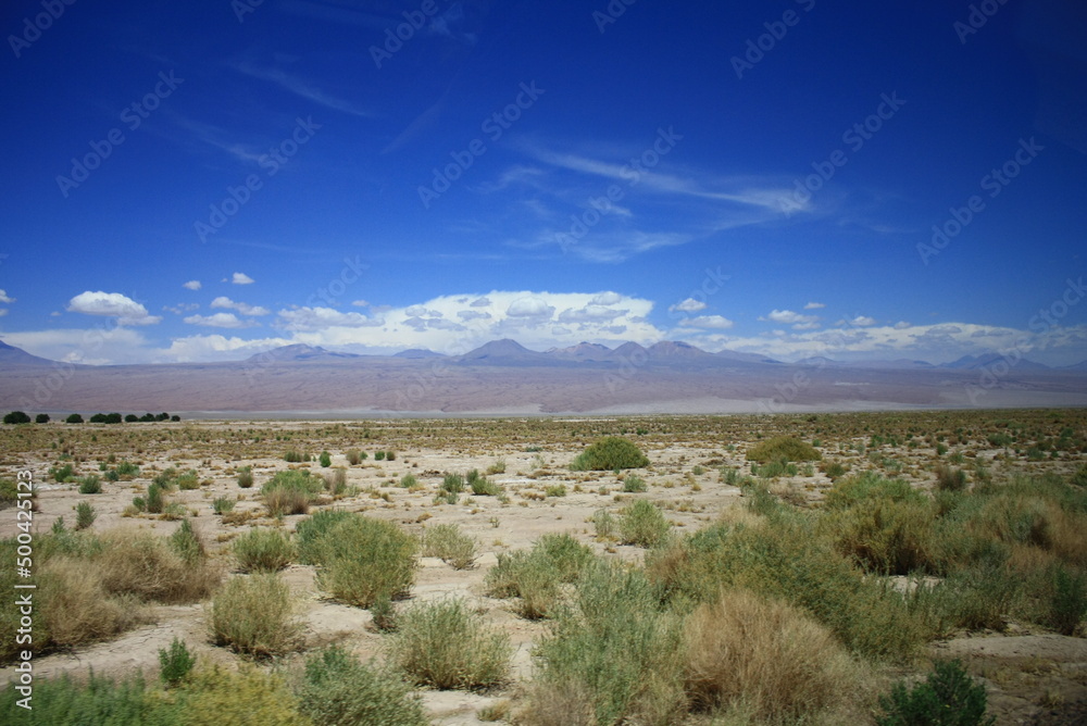 The landscape of the Atacama Desert in Chile, with clouds, volcano, lsand and salt.