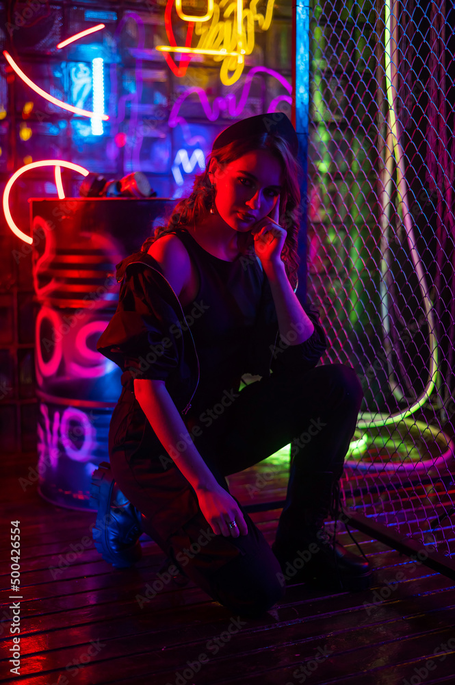 Caucasian woman posing in neon studio.