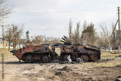 Barmashovo, Ukraine - March 18, 2022: War of Russia against Ukraine. Concept of invasion. Burned and destroyed tank (APC), armored personnel carrier in the center of village left after the battle. 