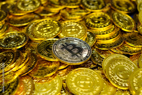 Golden bitcoin cryptocurrency on pile gold coins a lot of