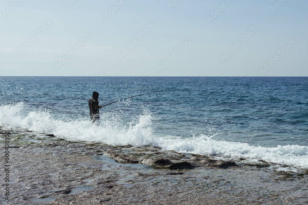 A man is fishing with fly fishing in the morning river, strong waves A man is fishing with fly fishing in the morning river, strong waves