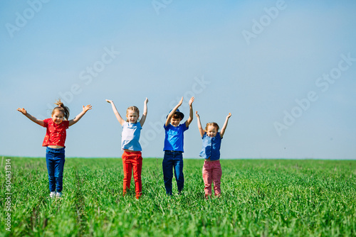 Running kids in green field during summer.