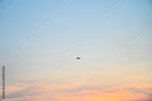 The plane flies. A passenger airplane on the sky. Jet flying at sunset.