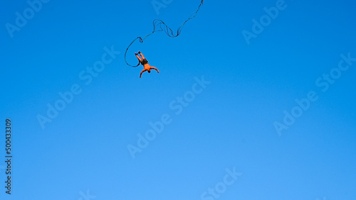 Bungee jumping. Young man is jumping from crane. Jump off a crane with a rope. Man having a good time bungee jumping. Extreme sport. photo