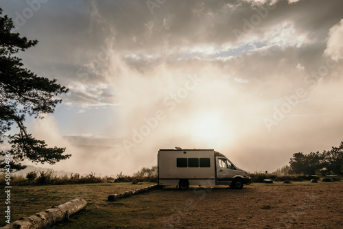 self build camper van parked up in a beautiful car park at sunset with wispy clouds and mist