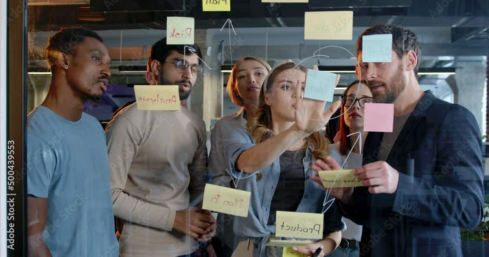 Team Task Races Mixed-races team of startup project talking about tasks and to-do notes ...