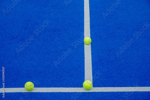 racket sports, three balls on the lines of a blue paddle tennis court © Vic