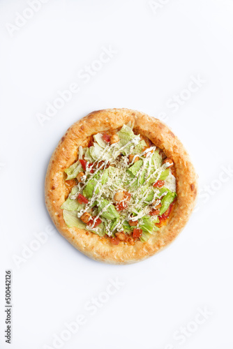 Homemade pizza with greens and sun-dried tomatoes. On a white background.